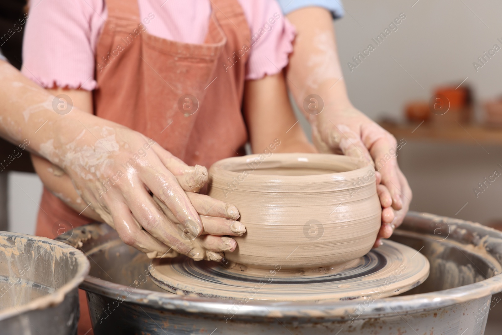 Photo of Hobby and craft. Daughter with her mother making pottery indoors, closeup