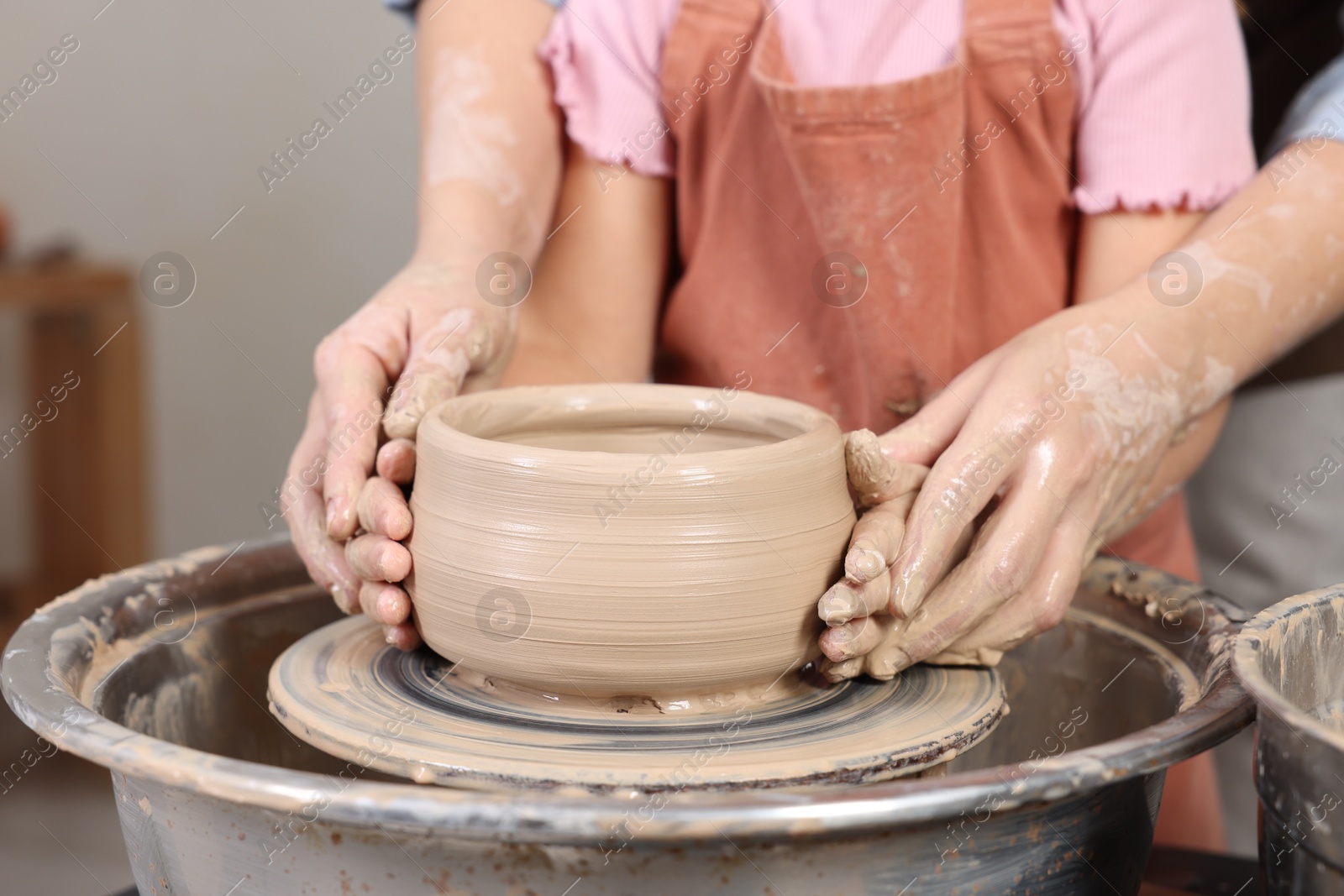 Photo of Hobby and craft. Daughter with her mother making pottery indoors, closeup