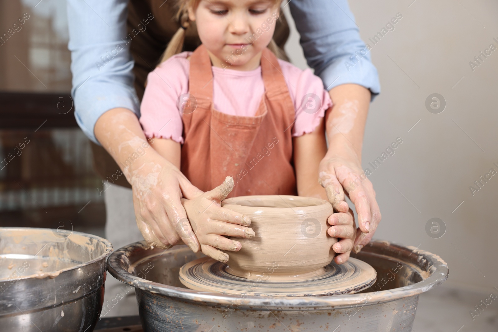 Photo of Hobby and craft. Daughter with her mother making pottery indoors, closeup