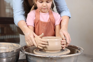 Photo of Hobby and craft. Daughter with her mother making pottery indoors, closeup