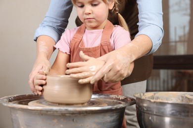 Photo of Hobby and craft. Daughter with her mother making pottery indoors, closeup