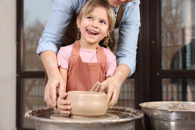 Photo of Hobby and craft. Happy daughter with her mother making pottery indoors, closeup