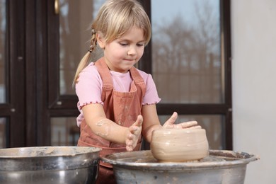 Photo of Hobby and craft. Little girl making pottery indoors