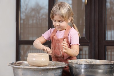 Photo of Hobby and craft. Little girl making pottery indoors