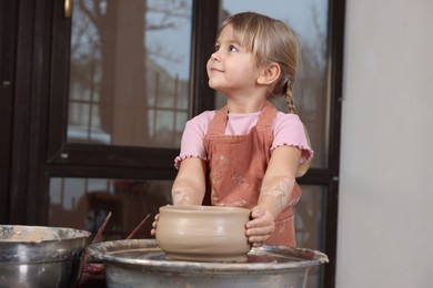 Photo of Hobby and craft. Little girl making pottery indoors