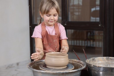 Photo of Hobby and craft. Little girl making pottery indoors