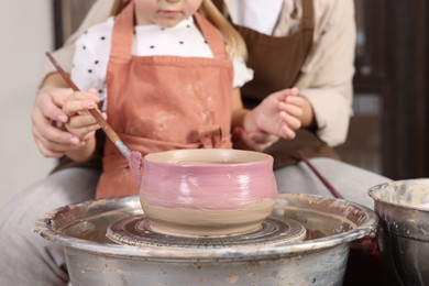 Photo of Hobby and craft. Daughter with her mother making pottery indoors, closeup