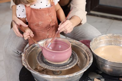 Photo of Hobby and craft. Daughter with her mother making pottery indoors, closeup