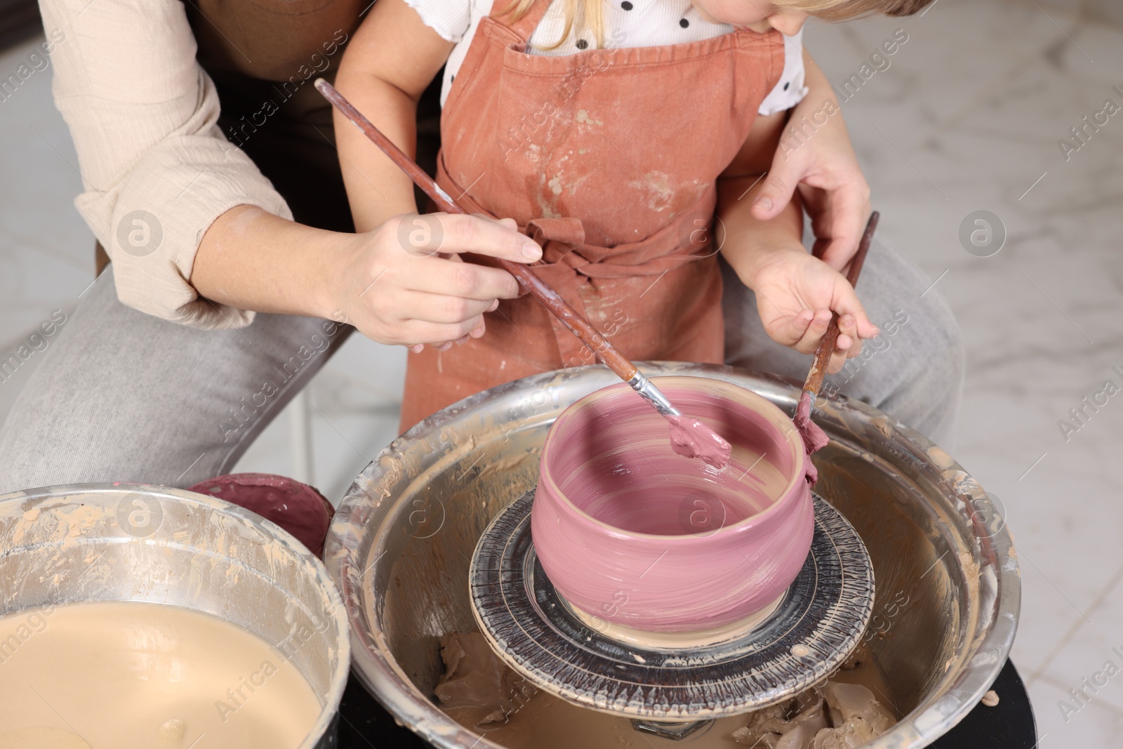 Photo of Hobby and craft. Daughter with her mother making pottery indoors, closeup