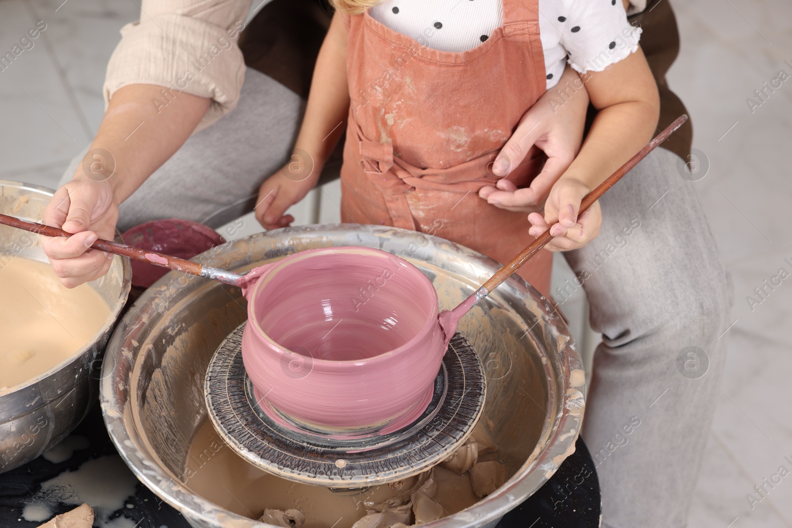 Photo of Hobby and craft. Daughter with her mother making pottery indoors, closeup