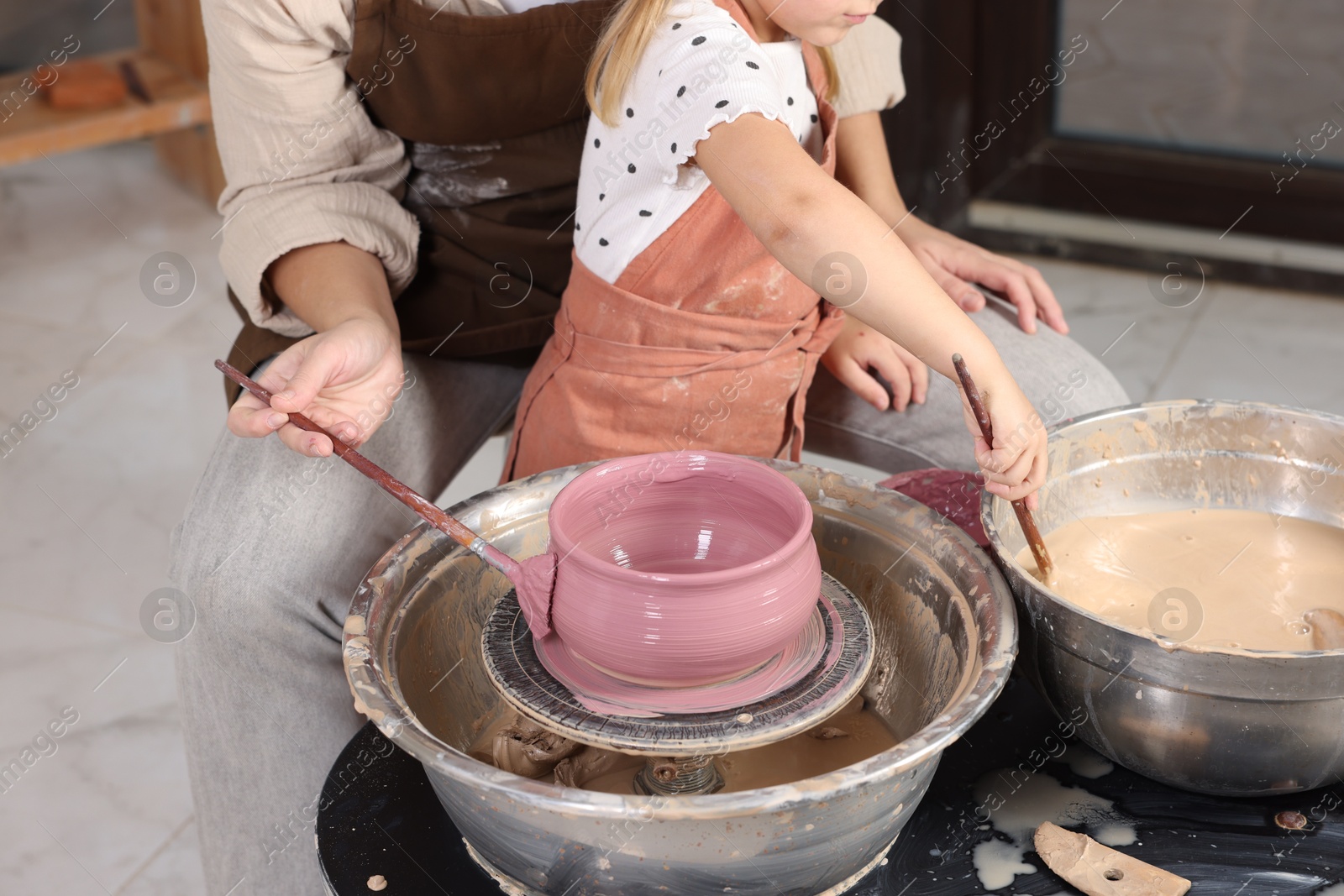 Photo of Hobby and craft. Daughter with her mother making pottery indoors, closeup