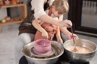 Photo of Hobby and craft. Daughter with her mother making pottery indoors, closeup