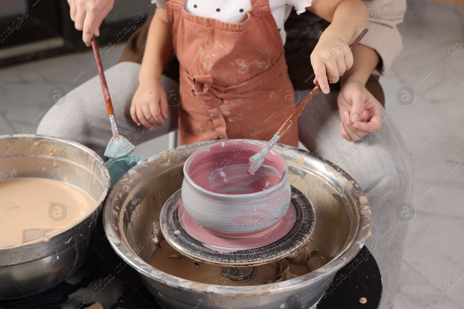 Photo of Hobby and craft. Daughter with her mother making pottery indoors, closeup