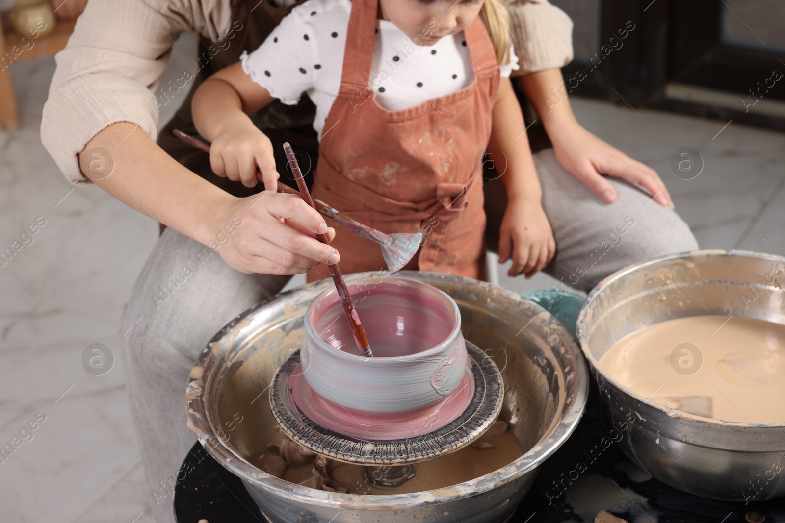 Photo of Hobby and craft. Daughter with her mother making pottery indoors, closeup