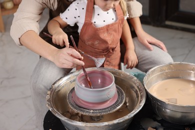 Photo of Hobby and craft. Daughter with her mother making pottery indoors, closeup