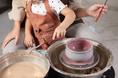 Photo of Hobby and craft. Daughter with her mother making pottery indoors, closeup