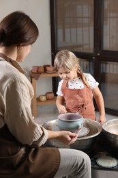 Photo of Hobby and craft. Daughter with her mother making pottery indoors