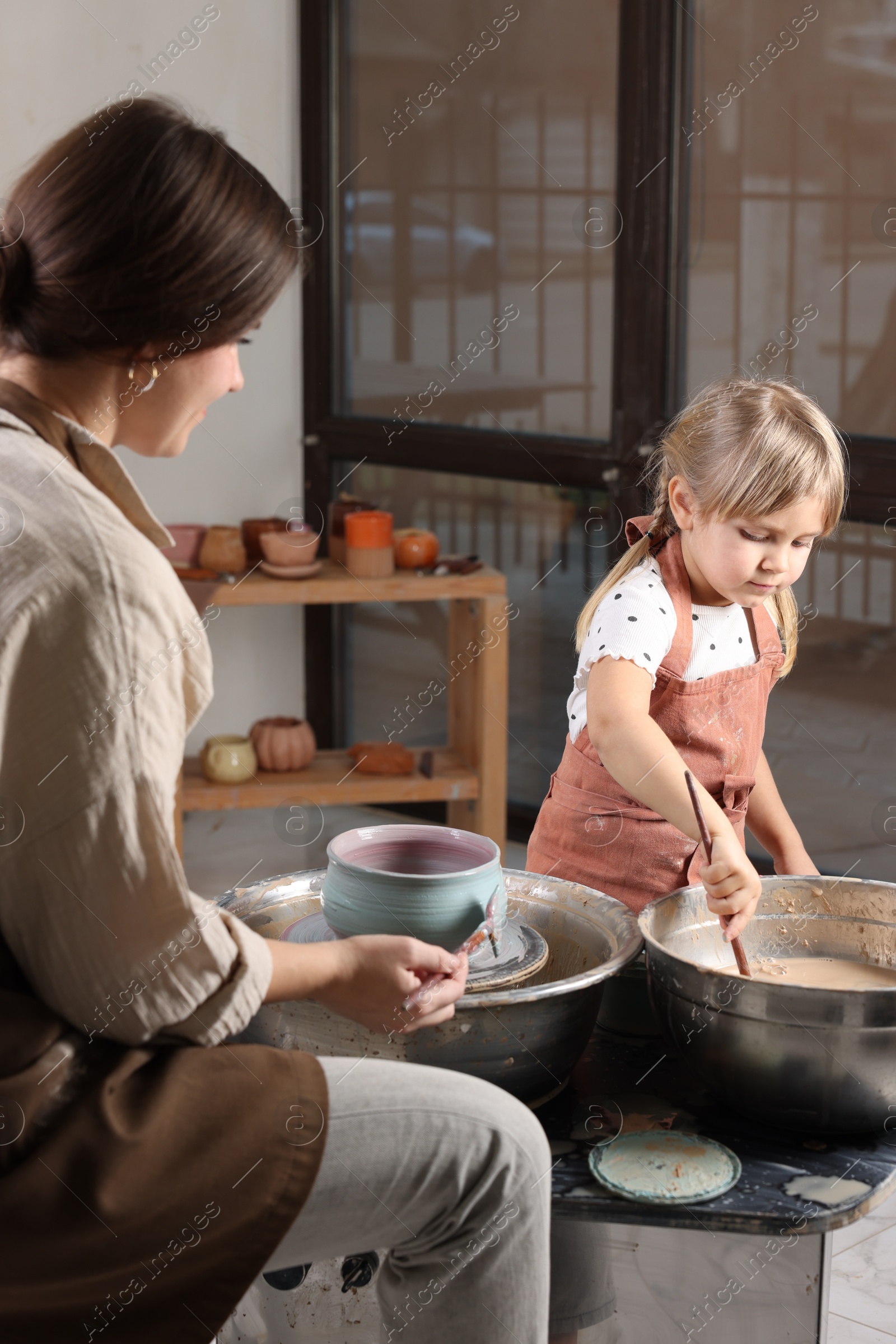 Photo of Hobby and craft. Daughter with her mother making pottery indoors