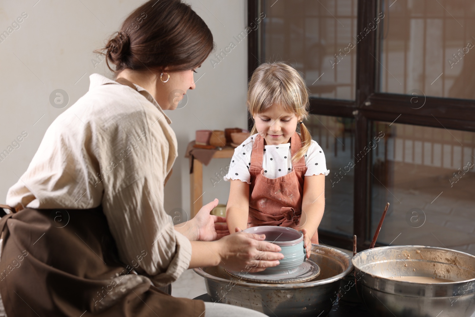 Photo of Hobby and craft. Daughter with her mother making pottery indoors