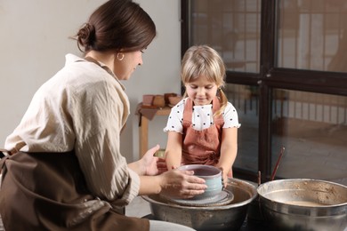 Photo of Hobby and craft. Daughter with her mother making pottery indoors