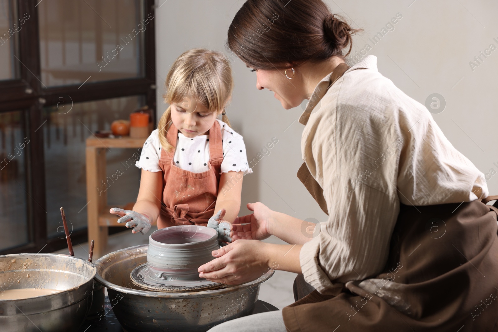 Photo of Hobby and craft. Daughter with her mother making pottery indoors