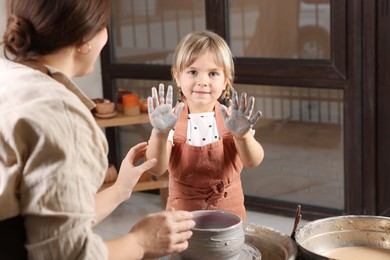 Photo of Hobby and craft. Daughter with her mother making pottery indoors