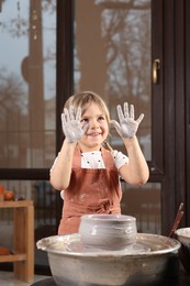 Photo of Hobby and craft. Smiling girl making pottery indoors