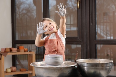 Photo of Hobby and craft. Smiling girl making pottery indoors