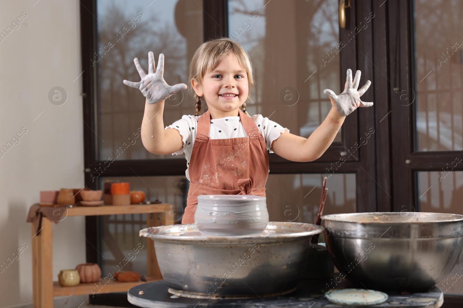 Photo of Hobby and craft. Smiling girl making pottery indoors