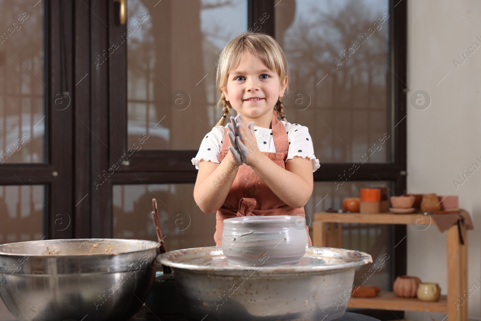 Photo of Hobby and craft. Smiling girl making pottery indoors