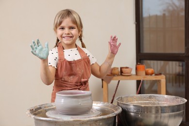 Photo of Hobby and craft. Smiling girl making pottery indoors