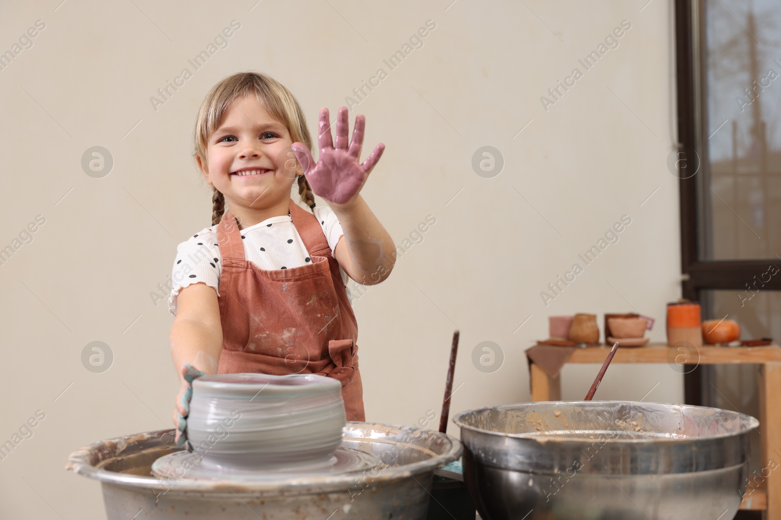 Photo of Hobby and craft. Smiling girl making pottery indoors