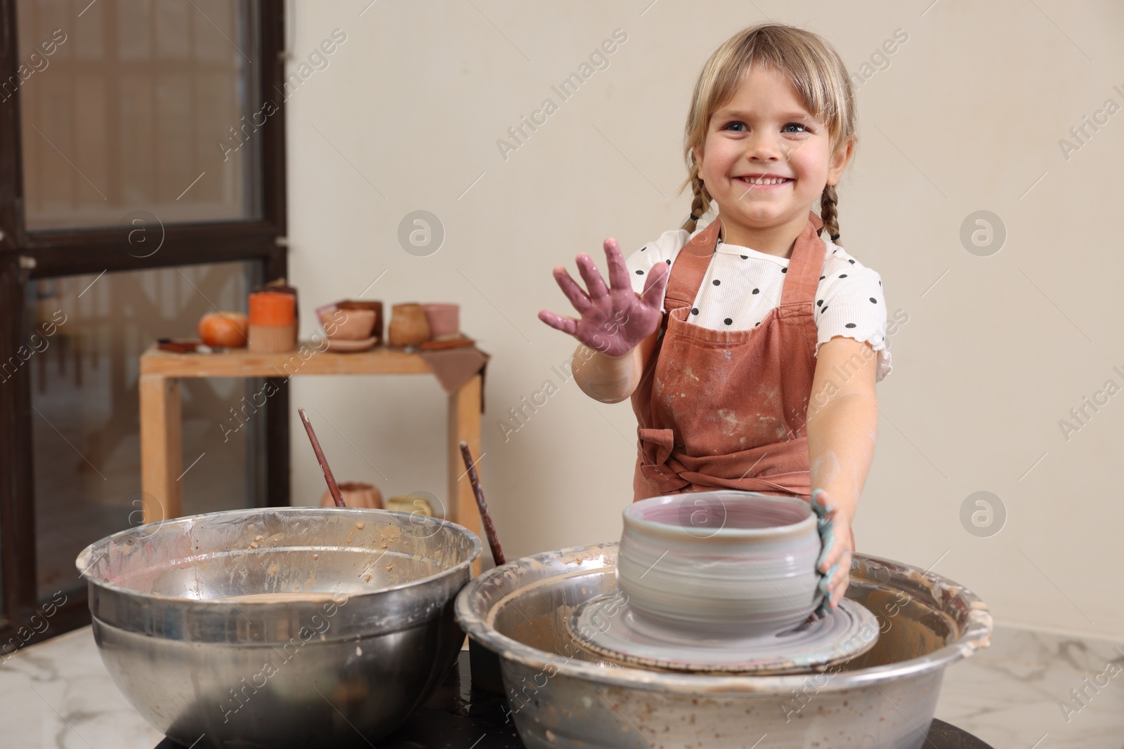 Photo of Hobby and craft. Smiling girl making pottery indoors