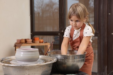 Photo of Hobby and craft. Little girl making pottery indoors