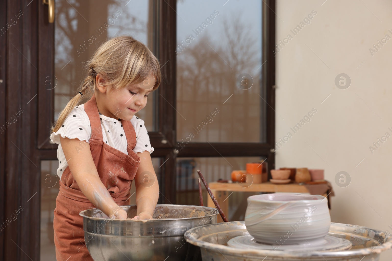 Photo of Hobby and craft. Little girl making pottery indoors