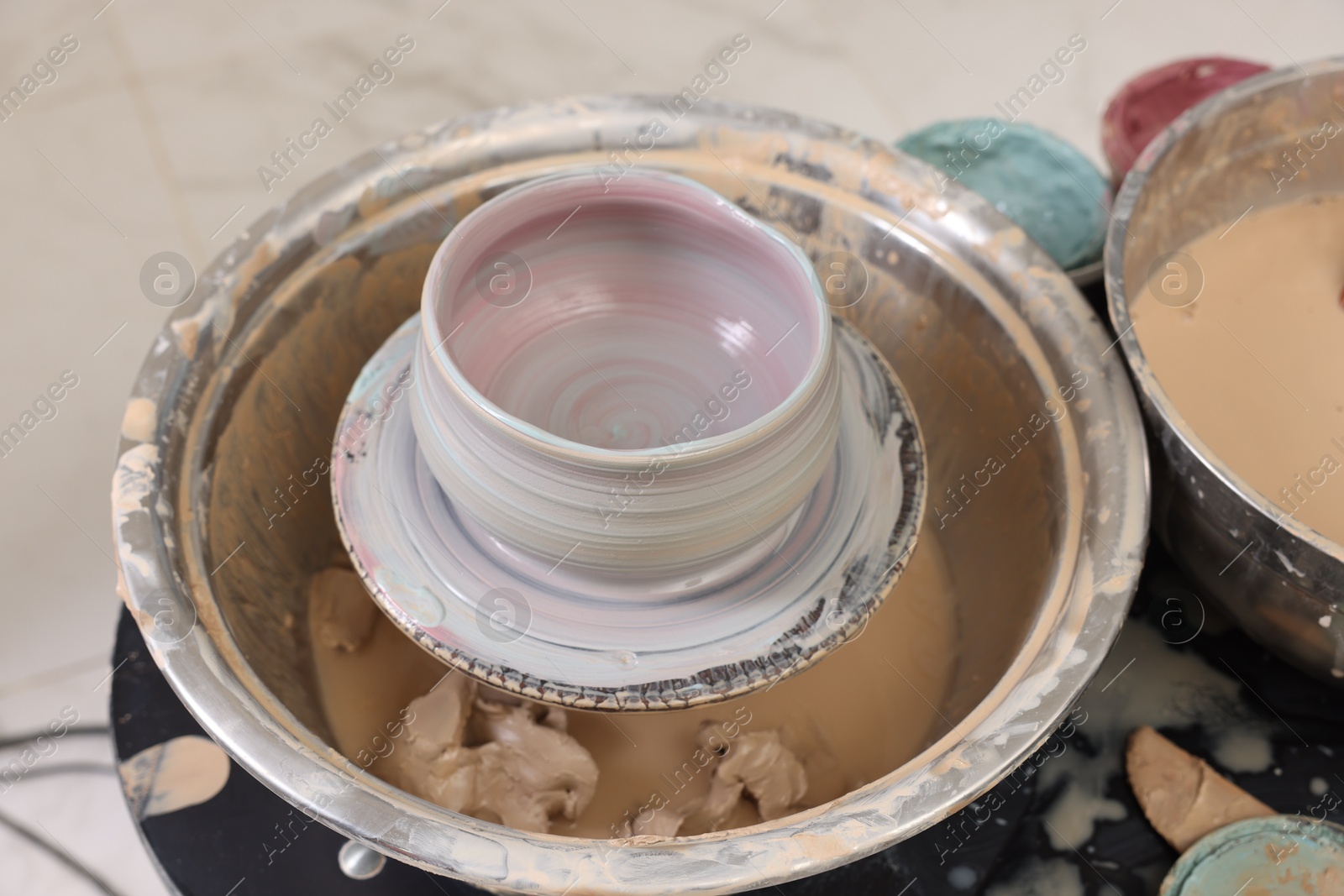 Photo of Hobby and craft. Beautiful bowl on potter's wheel in workshop