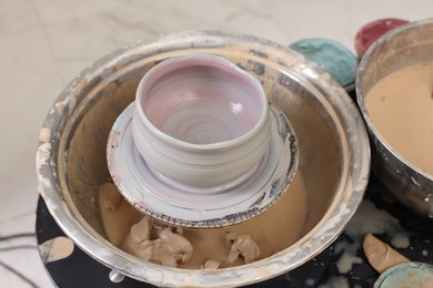 Photo of Hobby and craft. Beautiful bowl on potter's wheel in workshop