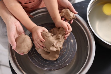 Photo of Hobby and craft. Mother with her daughter making pottery indoors, closeup