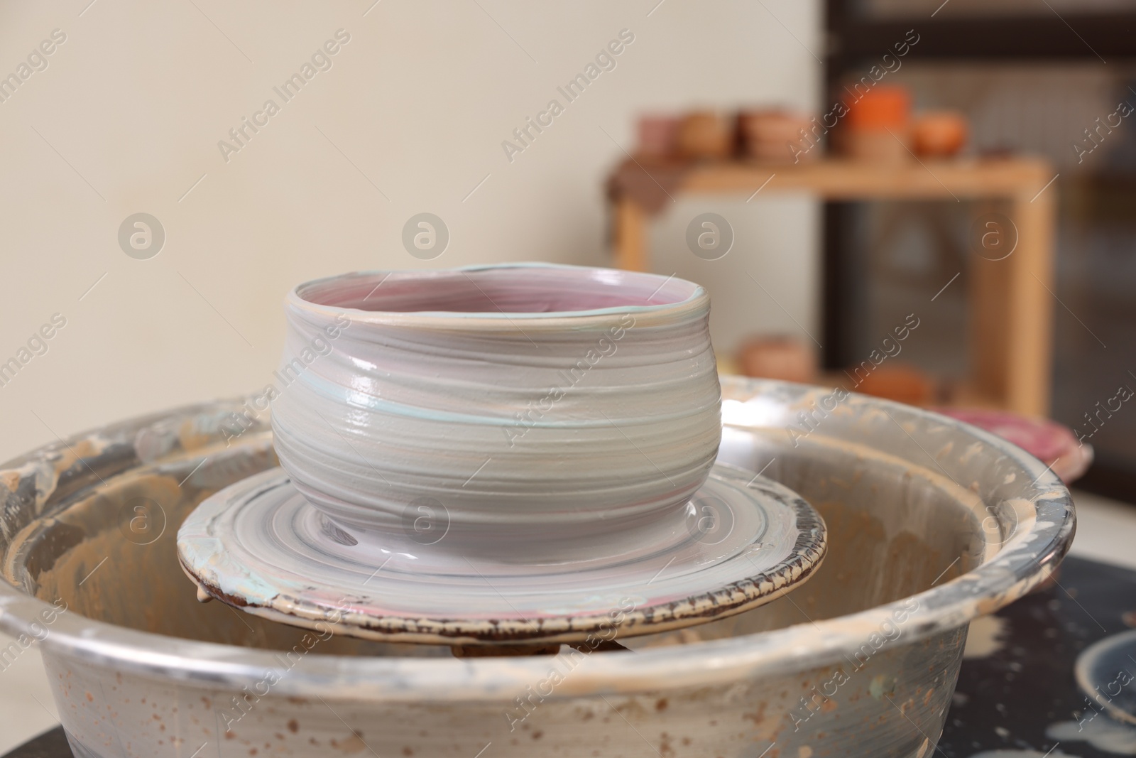 Photo of Hobby and craft. Beautiful bowl on potter's wheel in workshop, closeup