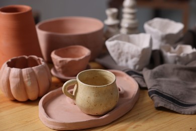 Photo of Hobby and craft. Different beautiful pottery on wooden table indoors, closeup