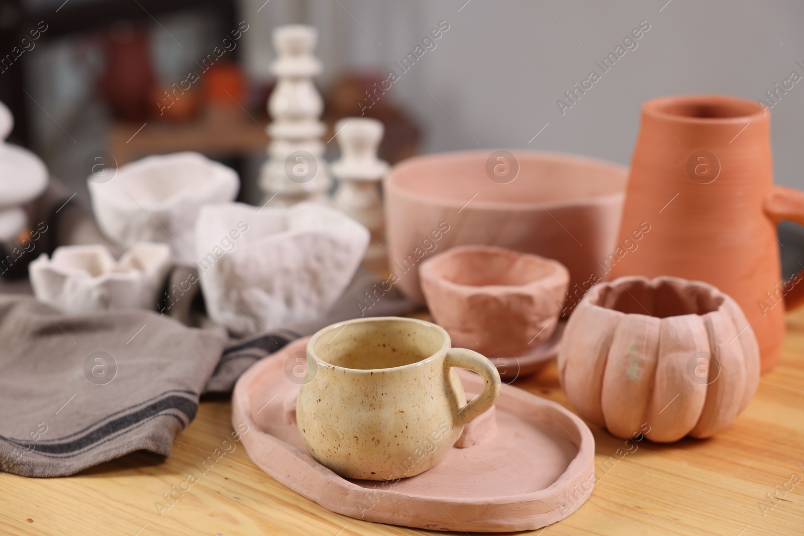 Photo of Hobby and craft. Different beautiful pottery on wooden table indoors, closeup