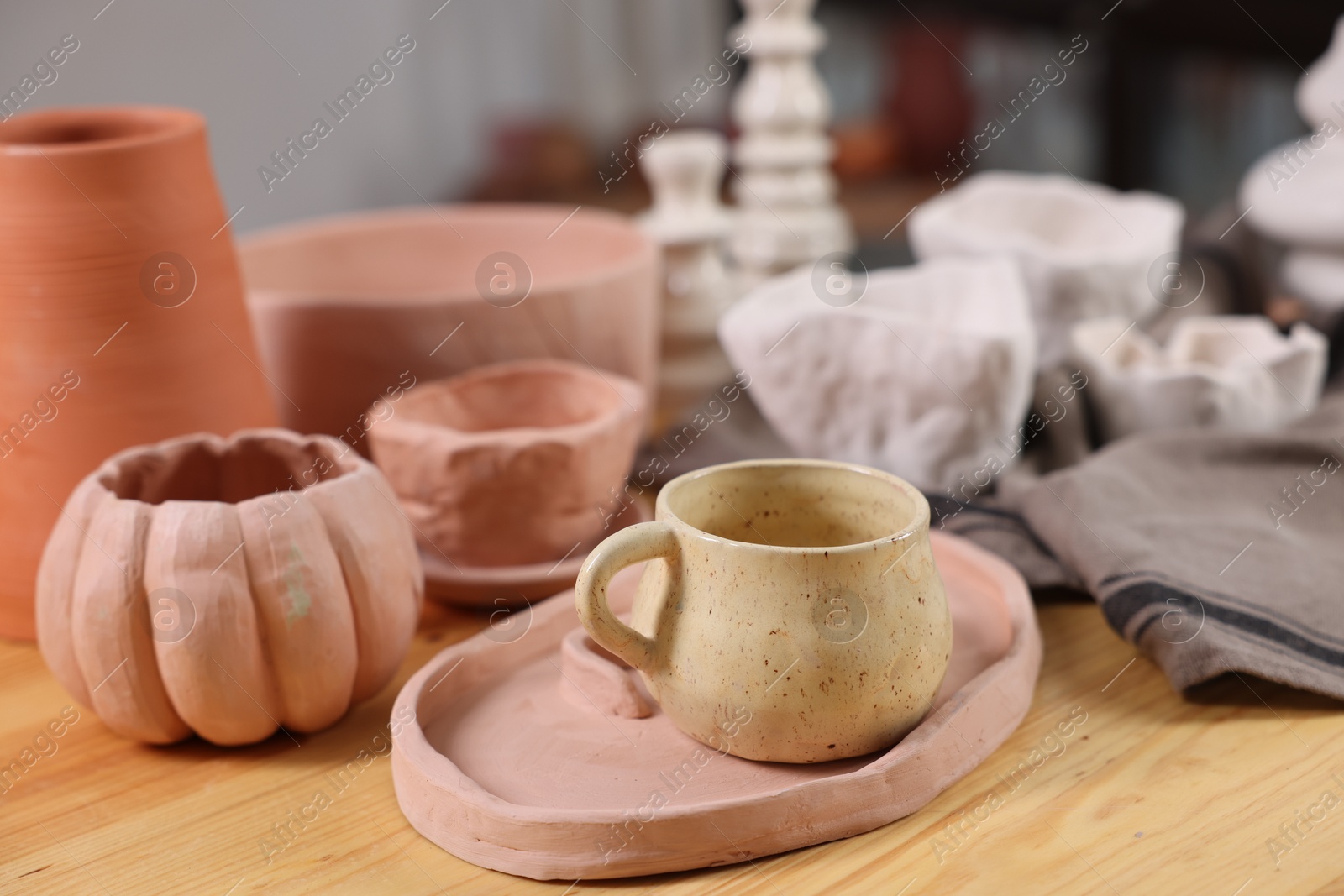 Photo of Hobby and craft. Different beautiful pottery on wooden table indoors, closeup