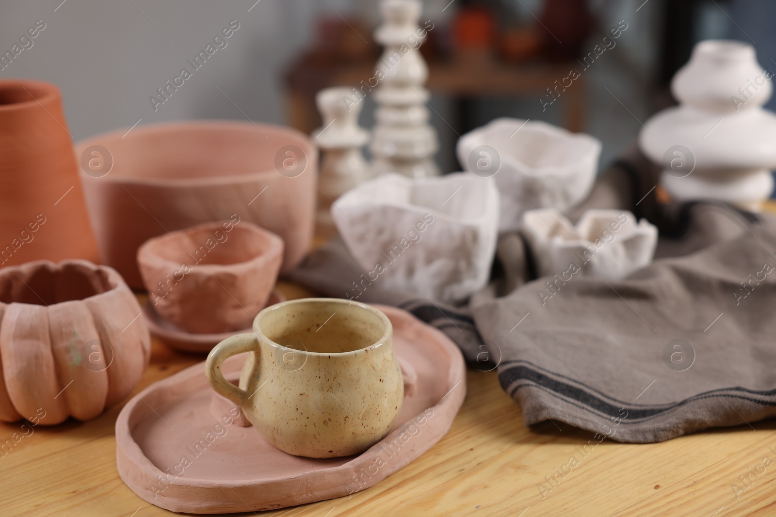 Photo of Hobby and craft. Different beautiful pottery on wooden table indoors, closeup