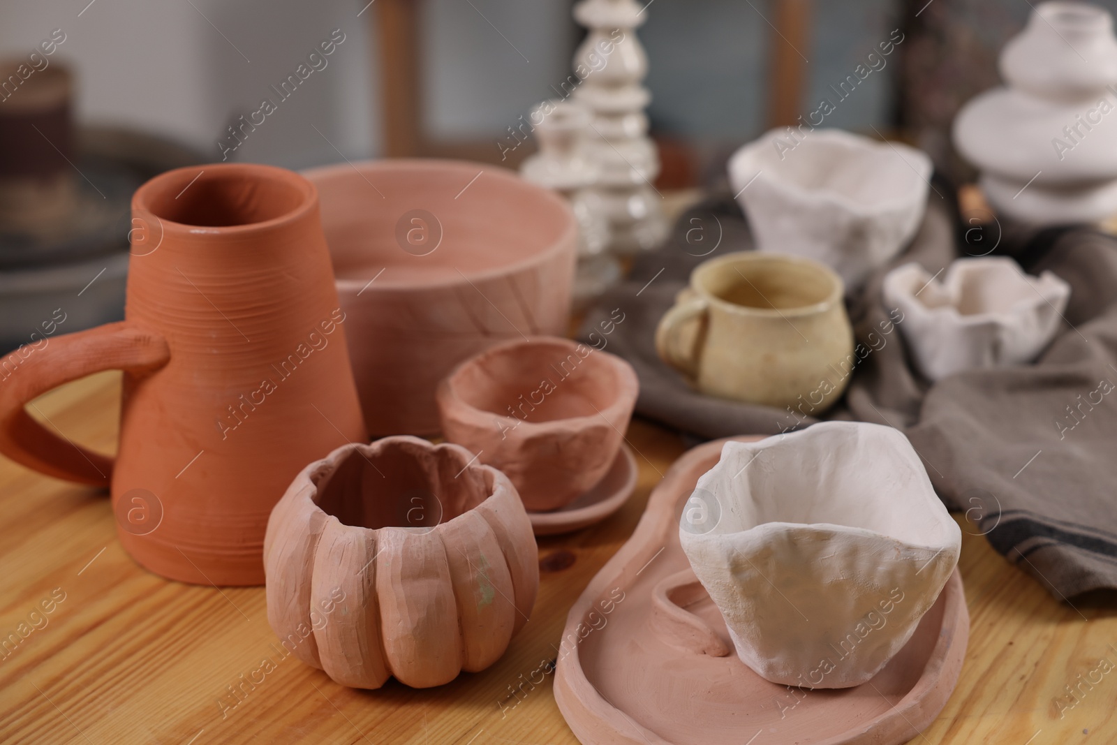 Photo of Hobby and craft. Different beautiful pottery on wooden table indoors, closeup