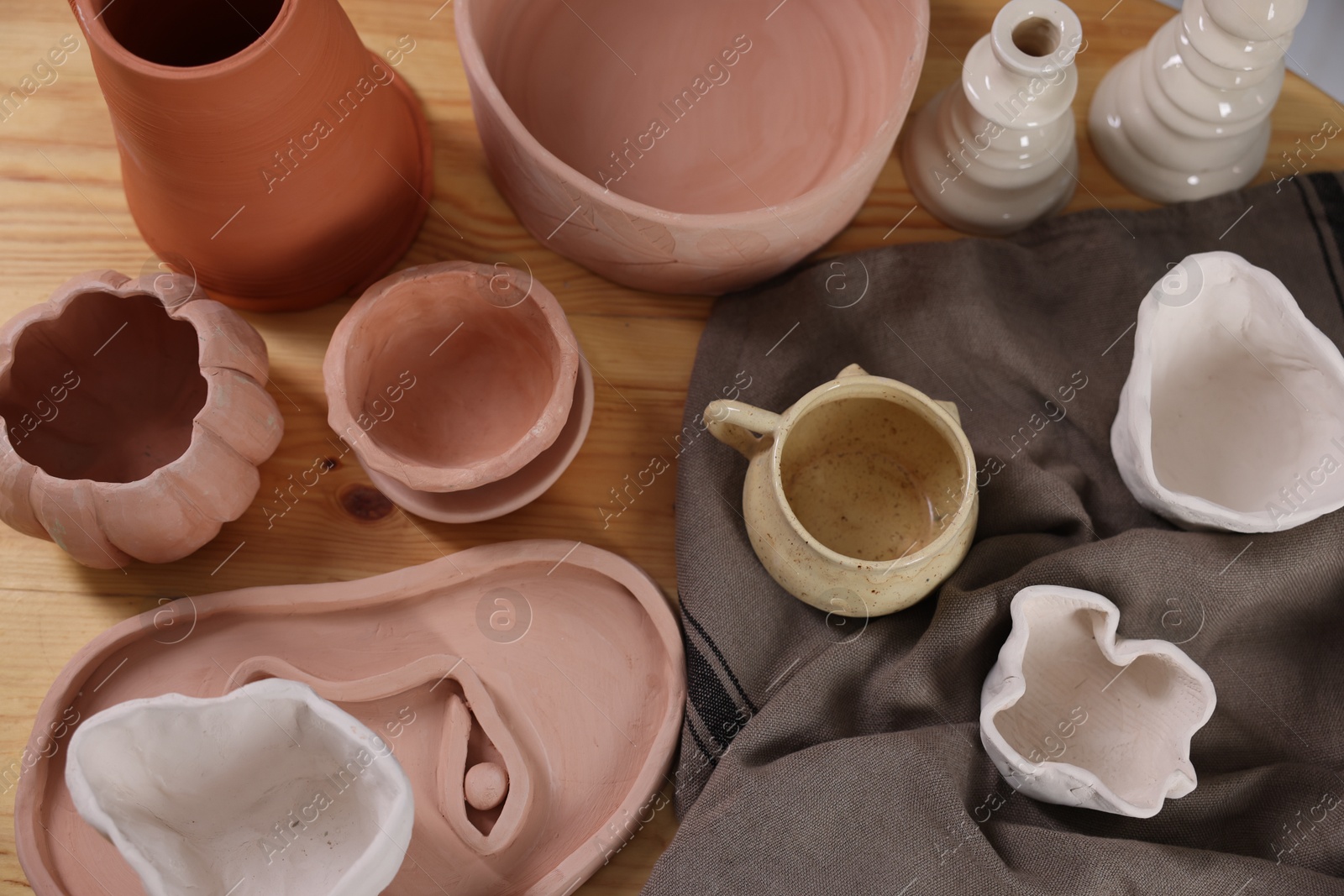 Photo of Hobby and craft. Different beautiful pottery on wooden table, flat lay