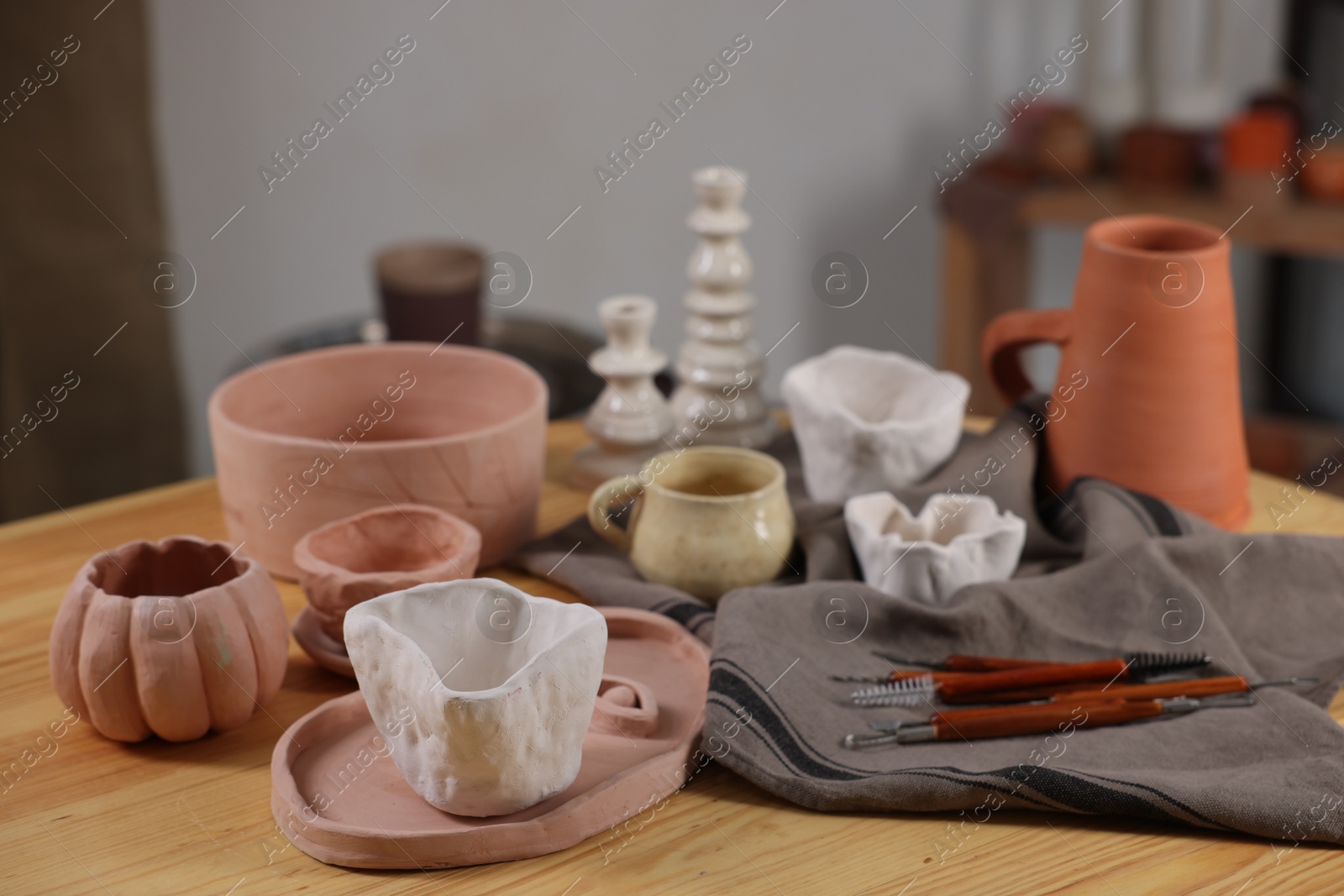 Photo of Hobby and craft. Different beautiful pottery on wooden table indoors, closeup