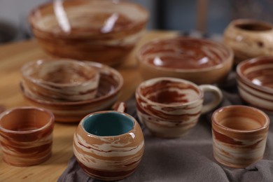 Photo of Hobby and craft. Different beautiful pottery on wooden table, closeup