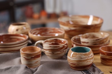 Photo of Hobby and craft. Different beautiful pottery on wooden table indoors, closeup