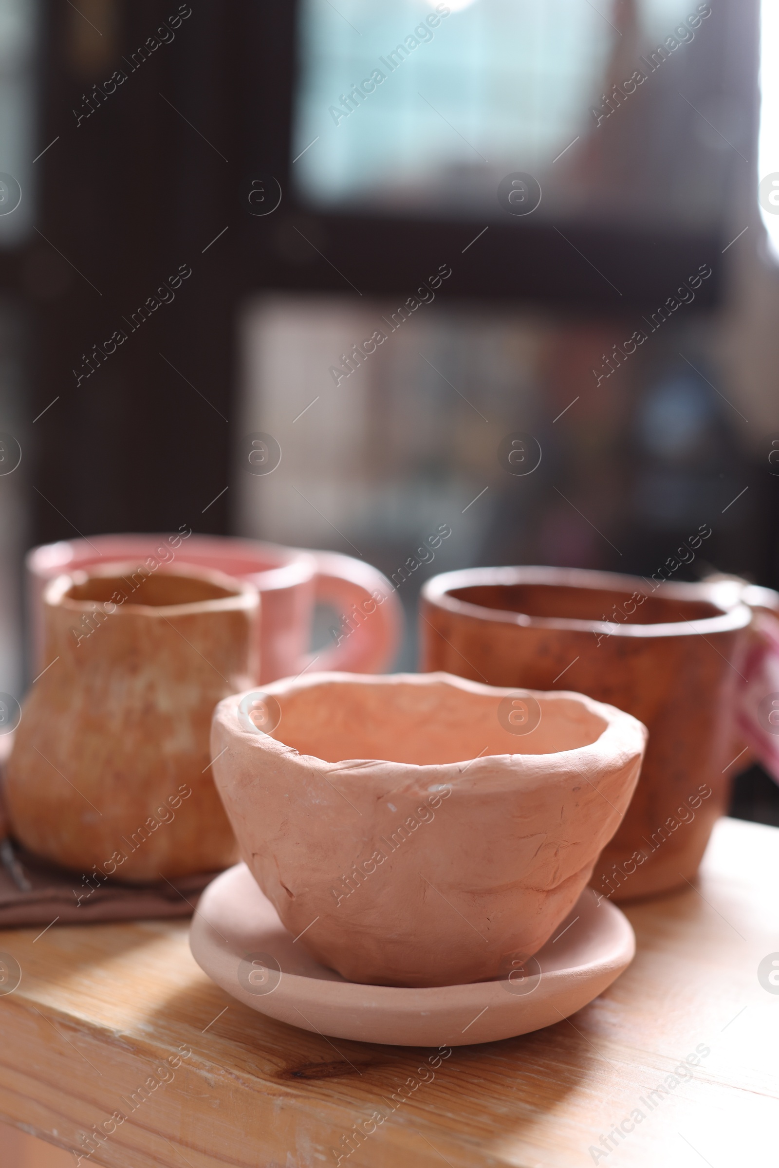 Photo of Beautiful pottery on wooden shelf indoors, closeup