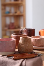 Photo of Set of different crafting tools and pottery on shelf indoors